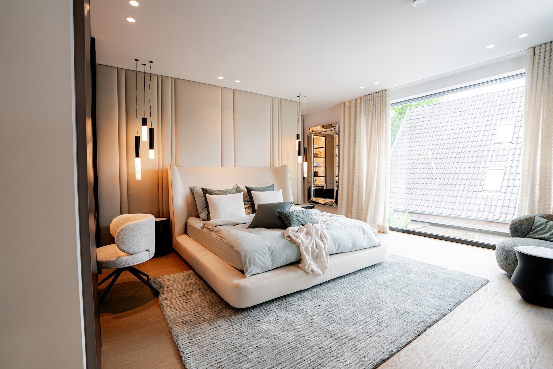 Helles Schlafzimmer mit Polsterbett, Wandpaneelen und Pendelleuchten