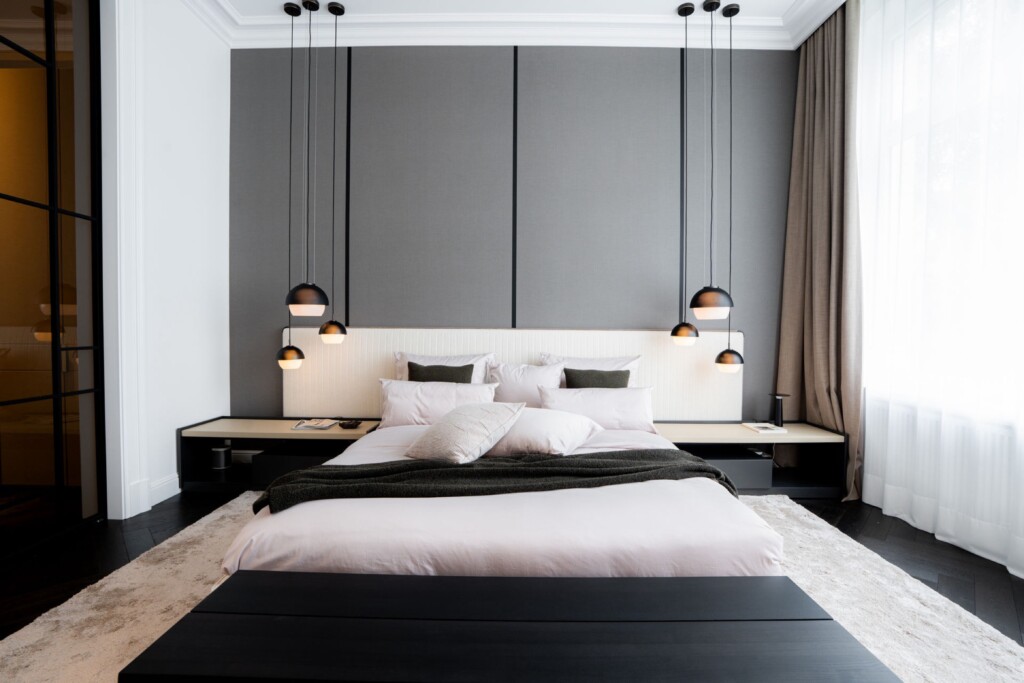 Schlafzimmer mit Pendelleuchten und Polsterbank im Altbau