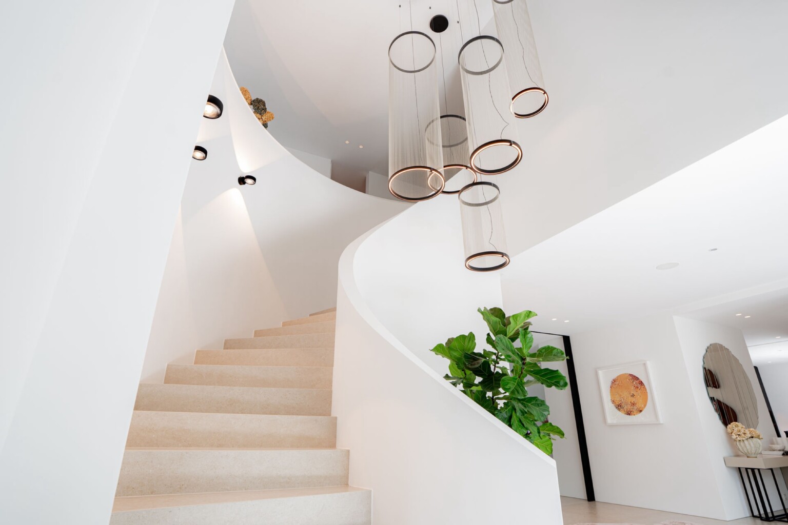 Weiße Wendeltreppe mit Ringleuchten in der Villa