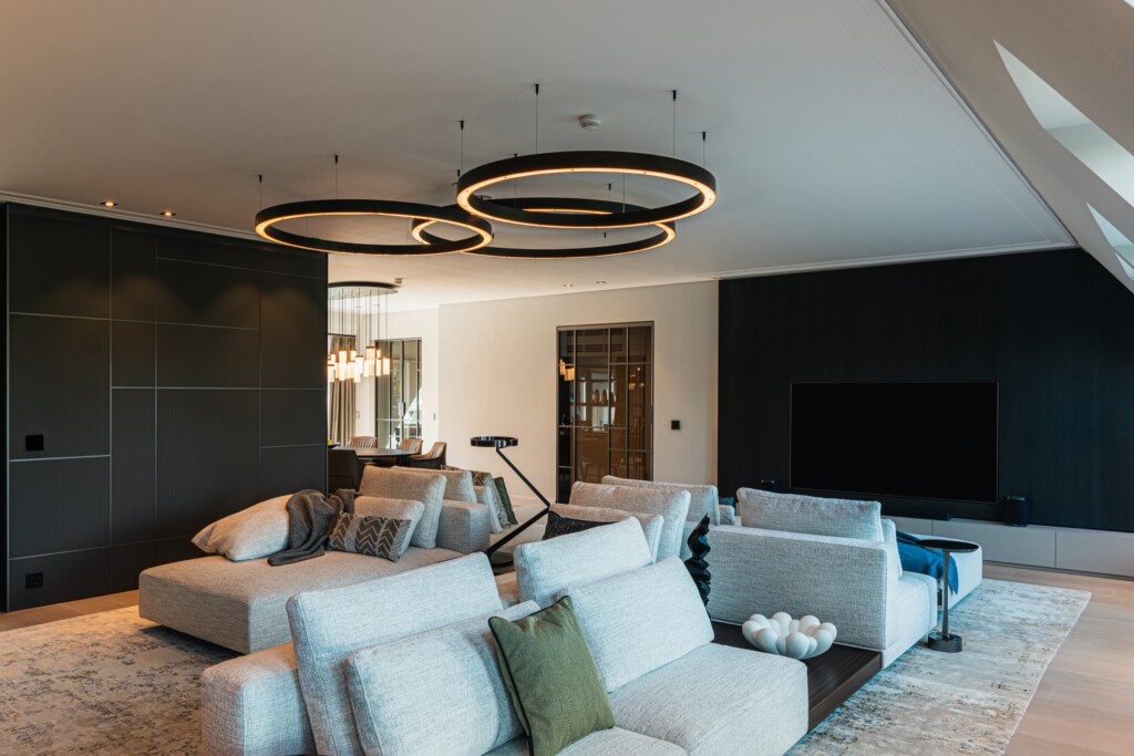 Wohnzimmer mit hellen Sofas unter Dachschrägen – Wohnung Carlstadt