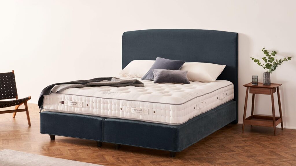 Vispring Herald Superb Bett mit dunkelblauem Divan und Kopfteil im Schlafzimmer